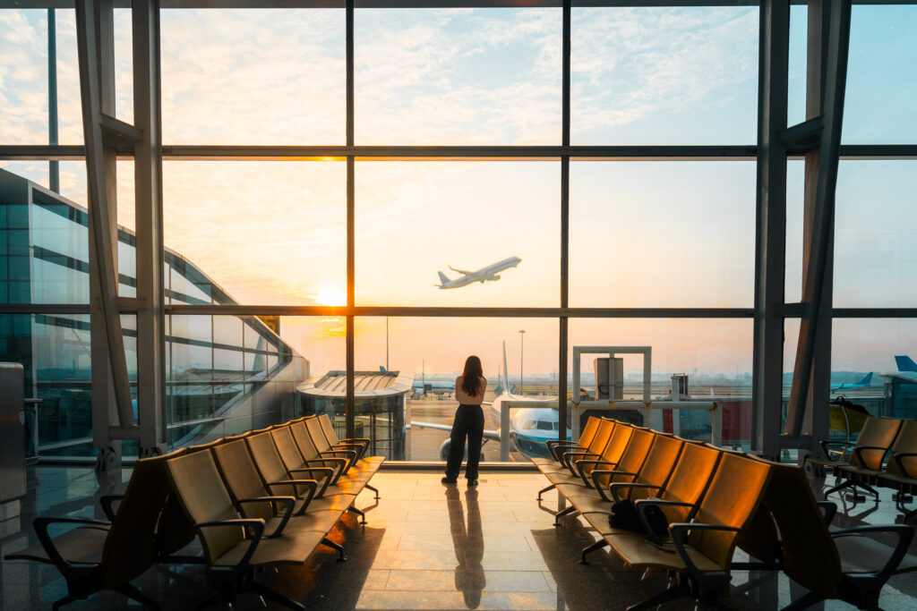Passenger on a long-haul flight looking out an airplane window during a journey
