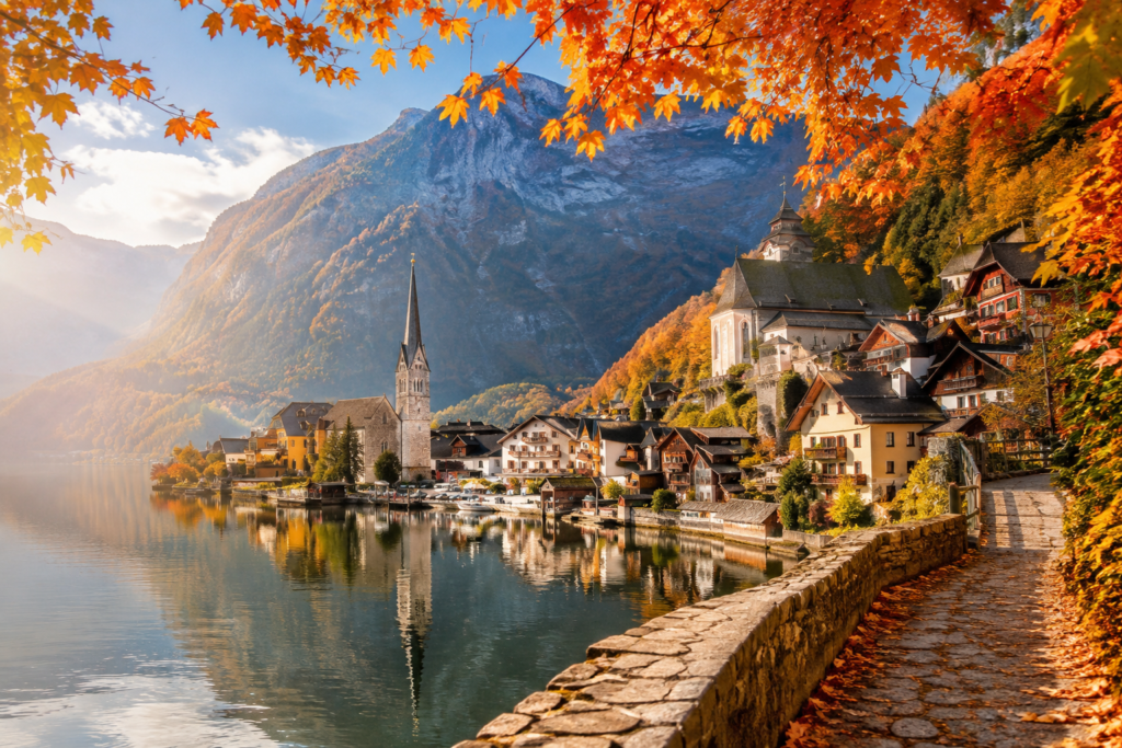 Scenic European lakeside village surrounded by golden autumn foliage and mountains